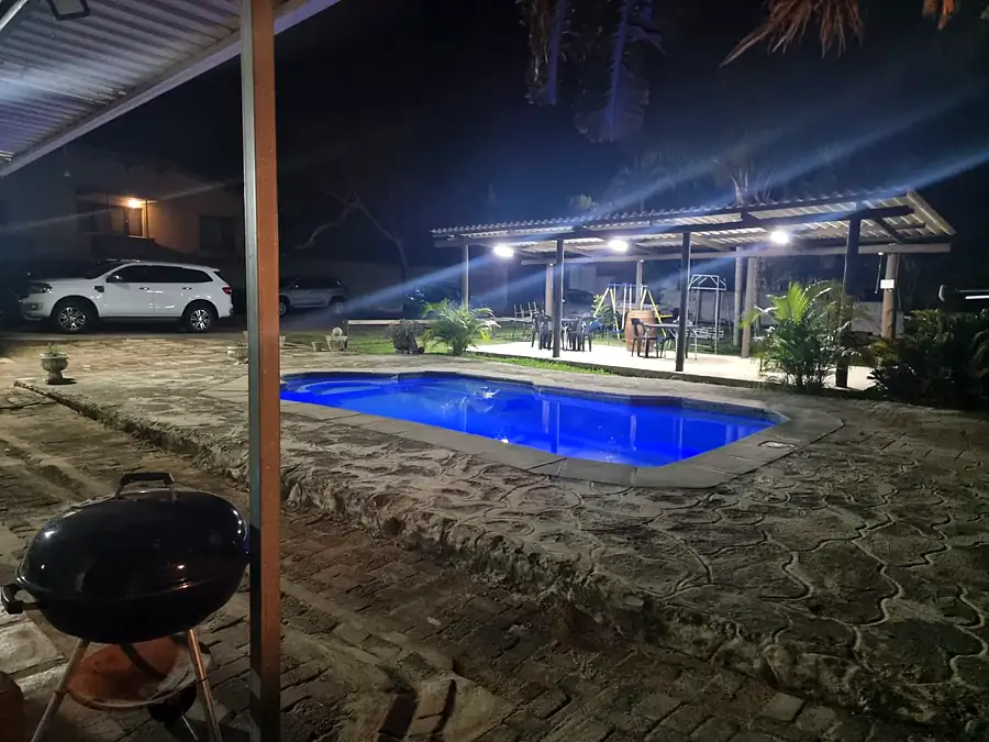 The pool and braai lit at night